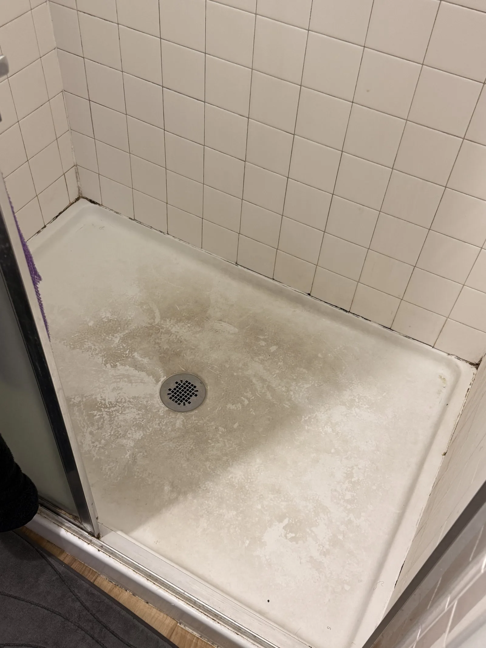 Grimy shower pan with soap scum buildup before L&G Cleaning's deep clean